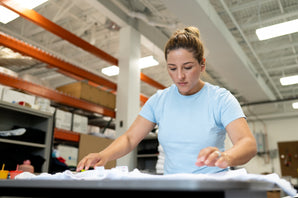 CheaterTee team member folding pretreated garments.